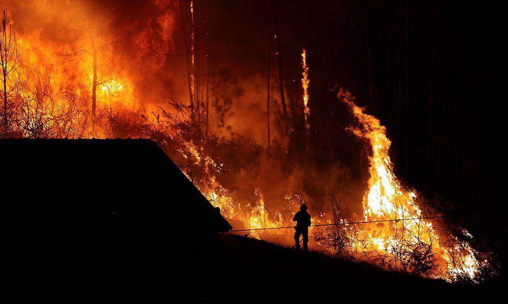 incendio in una foresta bosco e pericolo per una casa